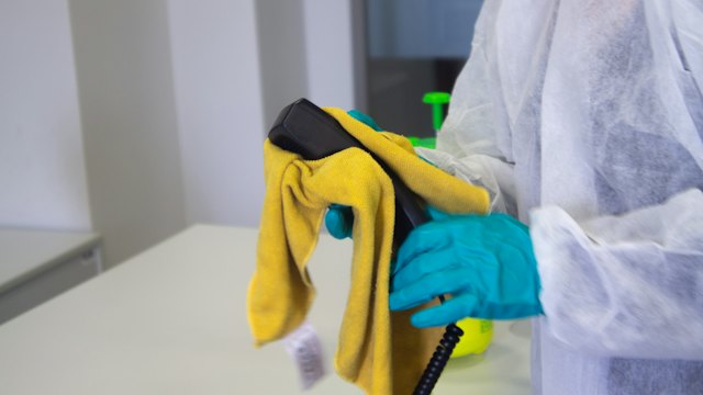 Worker in protective suit and gloves cleaning