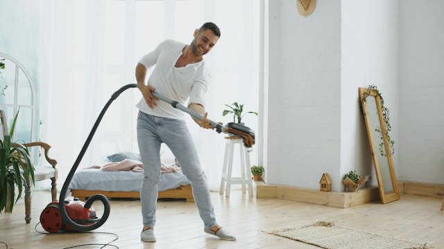 Man vacuuming a living room carpet