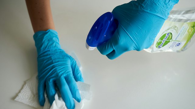 Gloved hand wiping a white surface