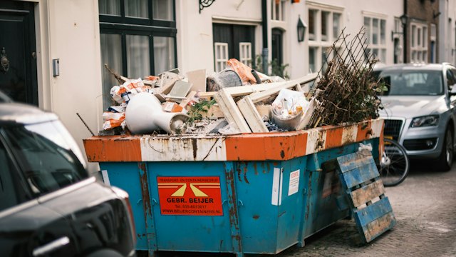 Dumpster full of household junk on a street
