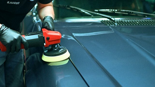 Detailer polishing a car with a buffer