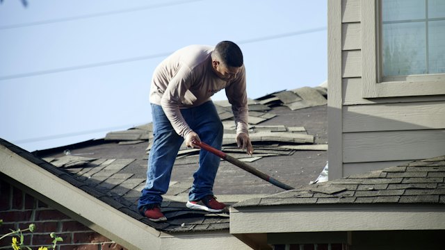 Roofer working on a shingle roof