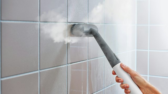 Steam cleaner on white wall tile
