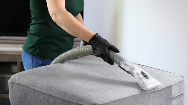 Cleaning a fabric ottoman with an upholstery tool